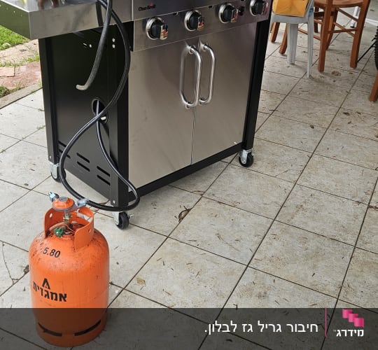 גריל גז עם בלון גז כתום על מרפסת